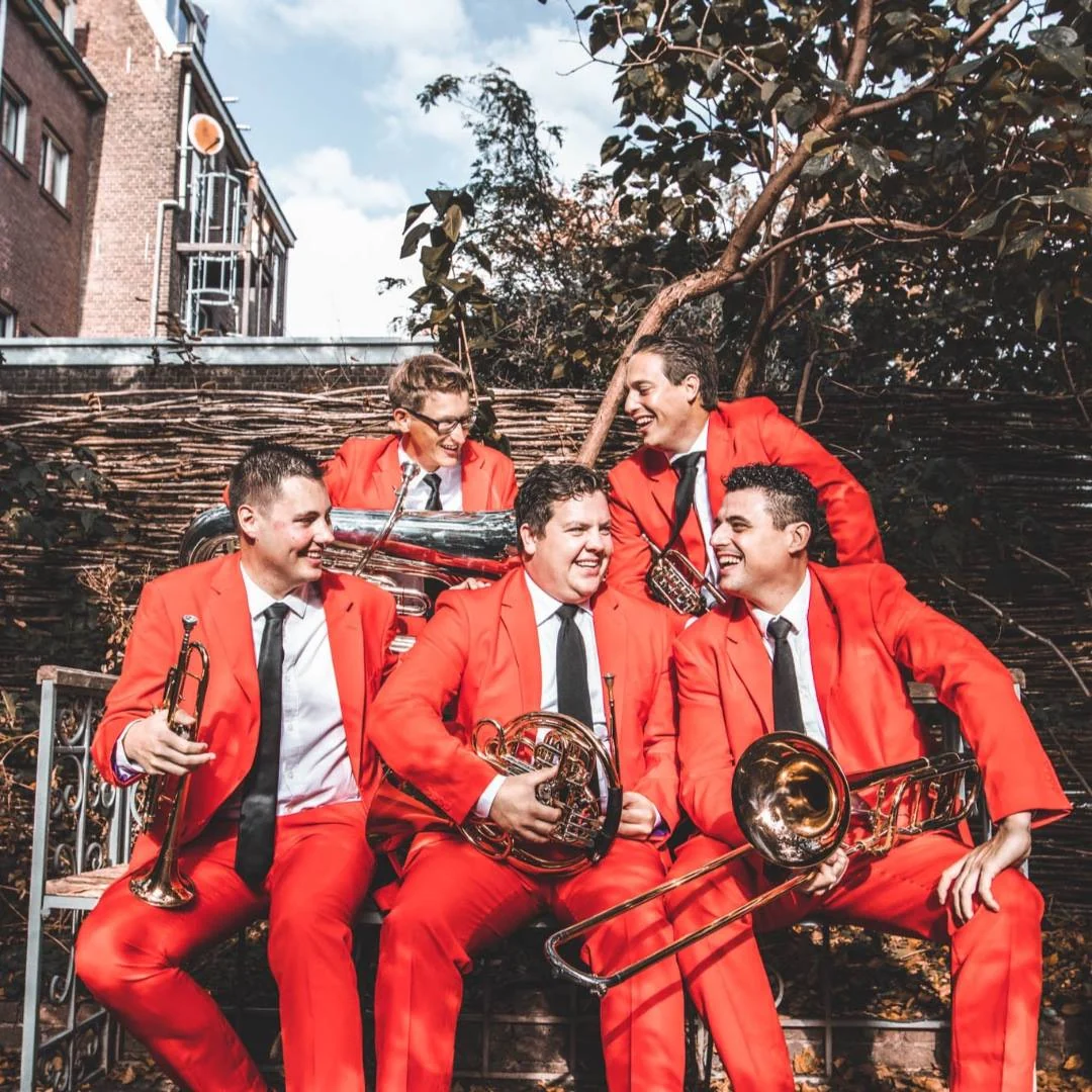 The five musicians of Pelgrim Brass in red suits